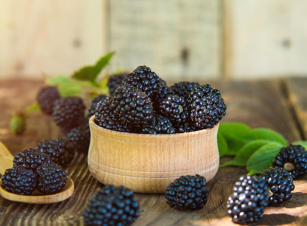 blackberries in a wooden bowl on an old wooden table Healthy forest fruits Selling blackberries