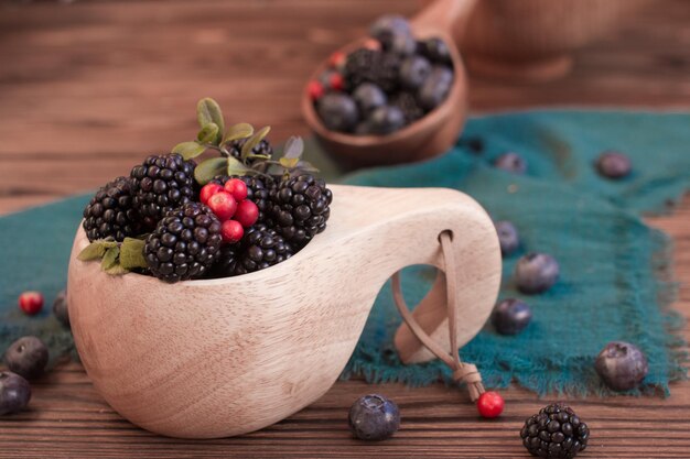 Blackberries in a wooden cup on the table Village concept