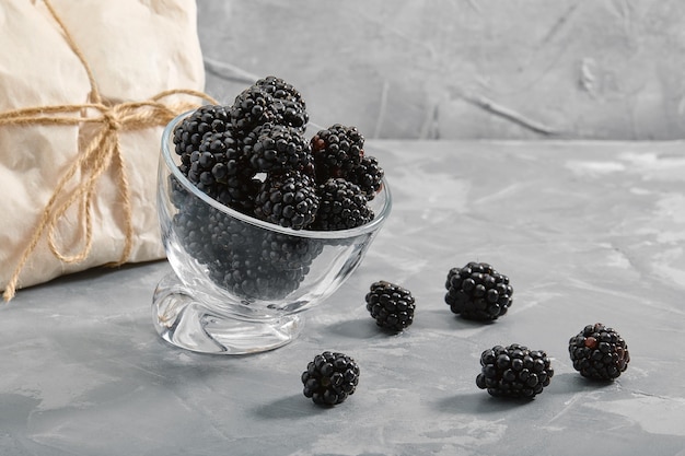 Blackberry on a black background closeup fresh berry in a bowl on a concrete background with a