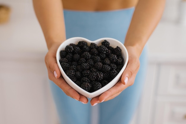 Blackberry harvest Collection of blackberries Plate with blackberries in hand Blackberry season