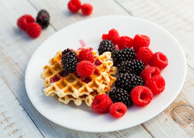 Blackberry and raspberry with a waffle on a white plate