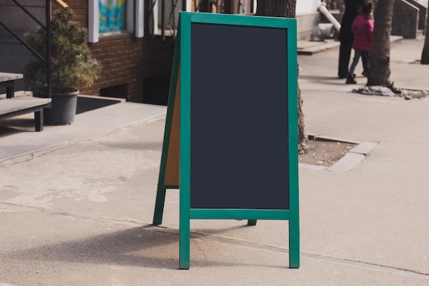 Photo blackboard in front of restaurant entrance mock up menu blank board sign stand near shop or cafe restaurant street magnetic sidewalk chalkboard