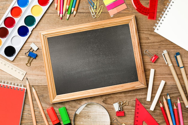 blackboard with copy space and stationery on wooden table