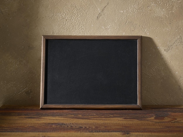 Blackboard in a wooden frame on a table in the interior of the room