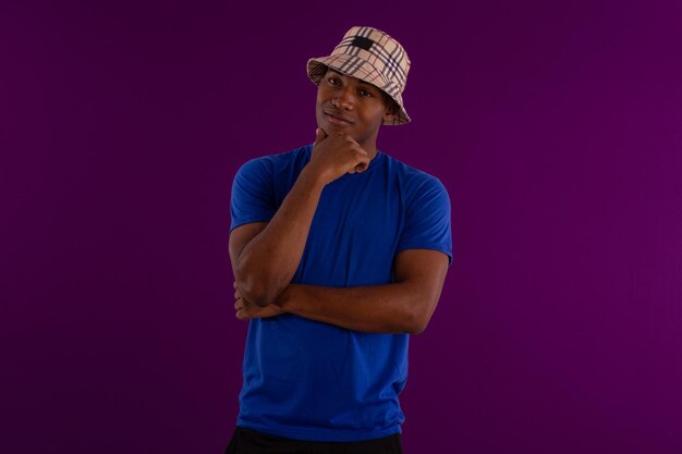 Blackskinned young adult man wearing a hat and shirt in studio photo