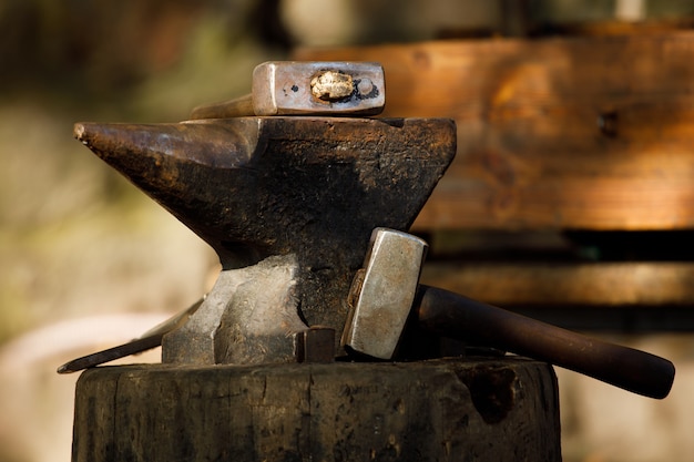 Photo blacksmith anvil with a hammer lie in nature