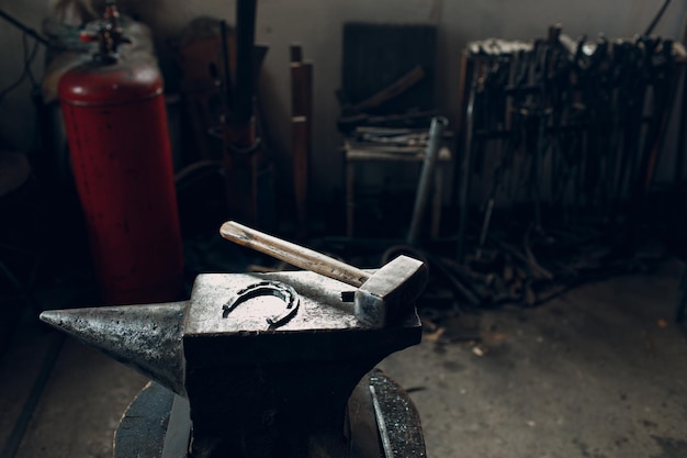 Blacksmith's hammer on metal anvil at forge Overhead view