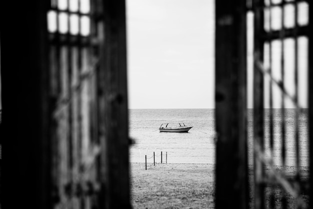 Blackwhite photography doors to alone boat in silent sea or ocean water