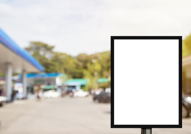 Blank advertising billboard or wide screen television with blurred gas station background