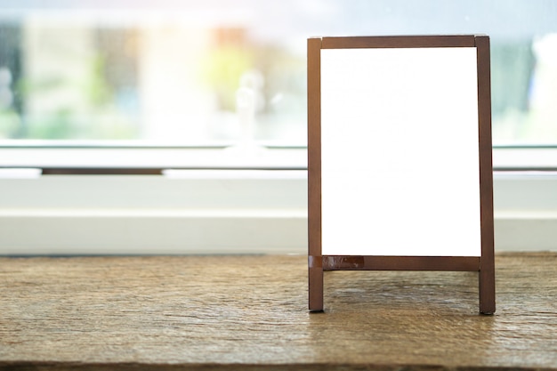 Blank advertising whiteboard with easel standing on table 