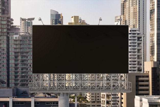 Blank black road billboard with Bangkok cityscape background at day time Street advertising poster mock up 3D rendering Front view The concept of marketing communication to promote or sell idea