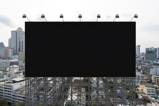 Blank black road billboard with Bangkok cityscape background at day time Street advertising poster mock up 3D rendering Front view The concept of marketing communication to promote or sell idea