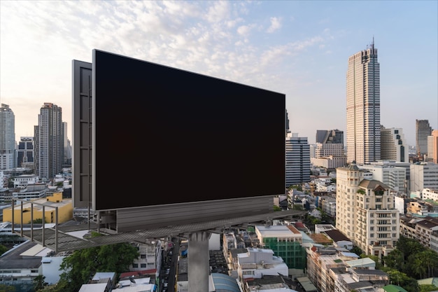 Blank black road billboard with Bangkok cityscape background at sunset Street advertising poster mock up 3D rendering Side view The concept of marketing communication to promote or sell idea