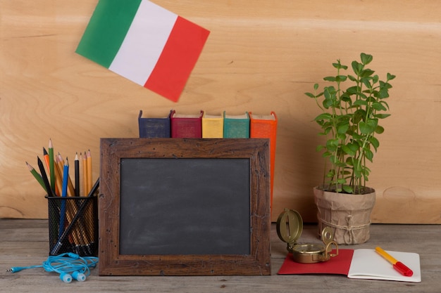 Blank blackboard flag of the Italy books chancellery on table and wooden background