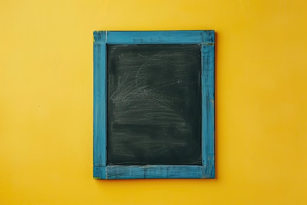 Photo blank blackboard with blue wooden frame on yellow