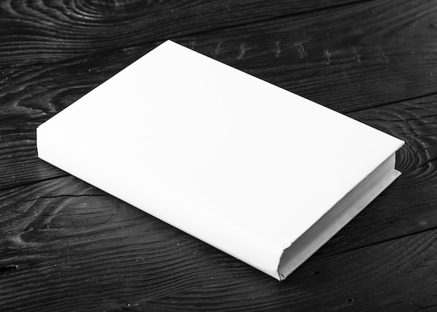 Blank book cover on black wooden  background