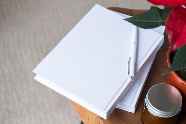 blank books with pen and poinsettia plant