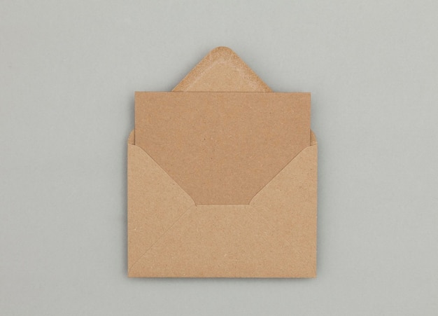 Blank brown kraft paper card and envelope on a grey background