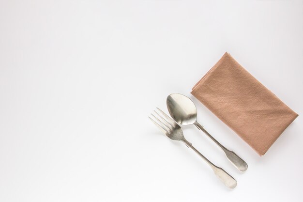 Blank brown restaurant napkin mockup with spoon and fork