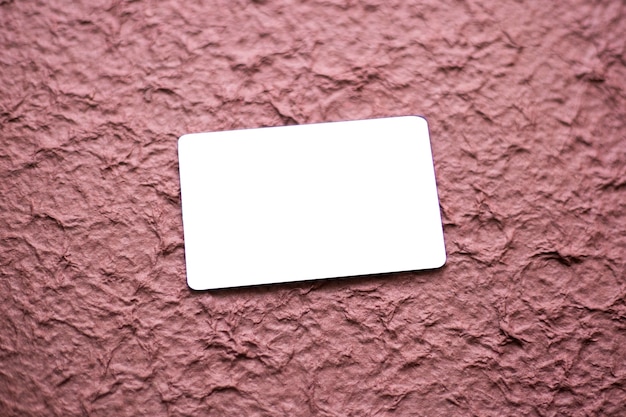 Blank business card isolated on textured magenta background