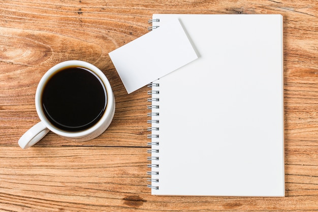 Blank business cards and cup of coffee on wooden table. Corporate stationary branding mock up.