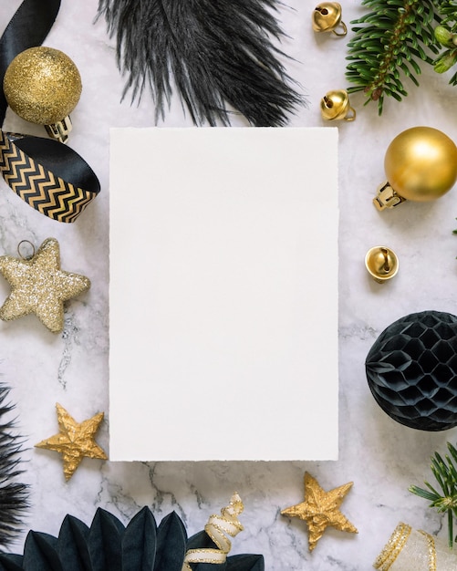 Photo blank card between black and golden christmas decorations and fir tree branches top view