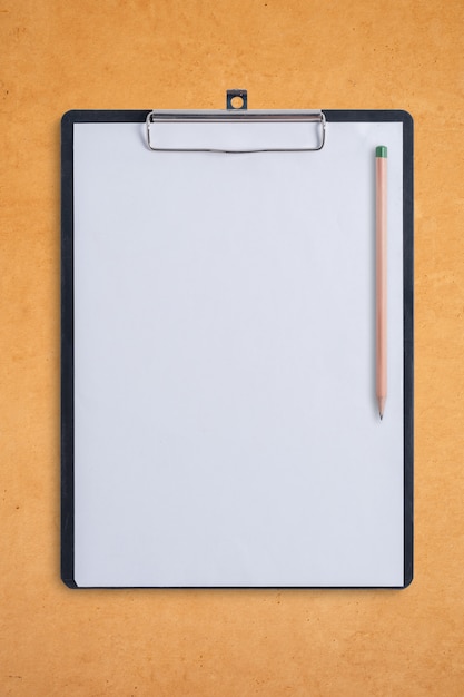 Blank clipboard and pen on brown wood board