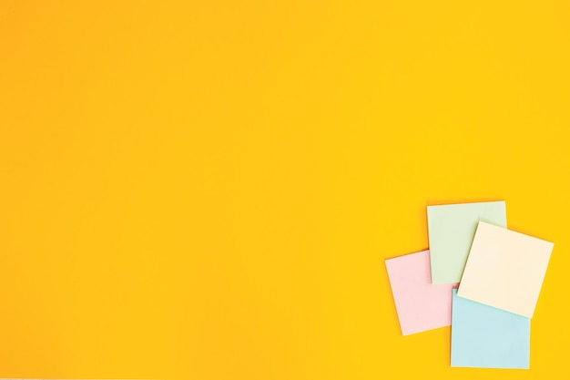 Blank colorful sticky notes on yellow background flat lay