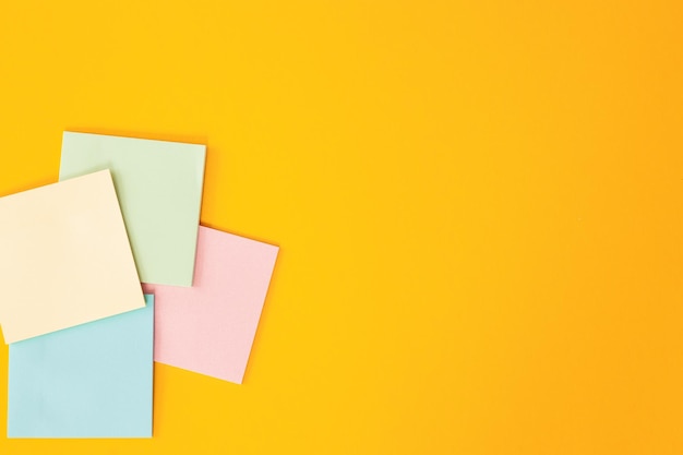 Blank colorful sticky notes on yellow background flat lay