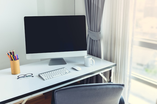 Blank computer desktop with keyboard, diary and other accesories on white table