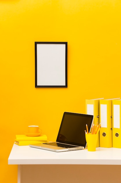 Blank frame on yellow wall front view