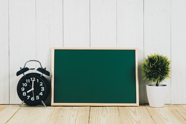 Blank green chalk board and little decorative tree on wood