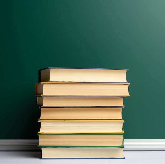 Blank green chalk school board and stack of books, back to school, copy space