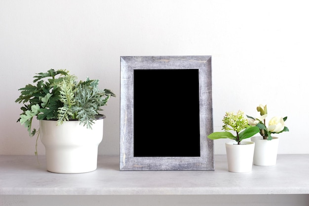 Blank grey vintage wooden frame on table and white wall background