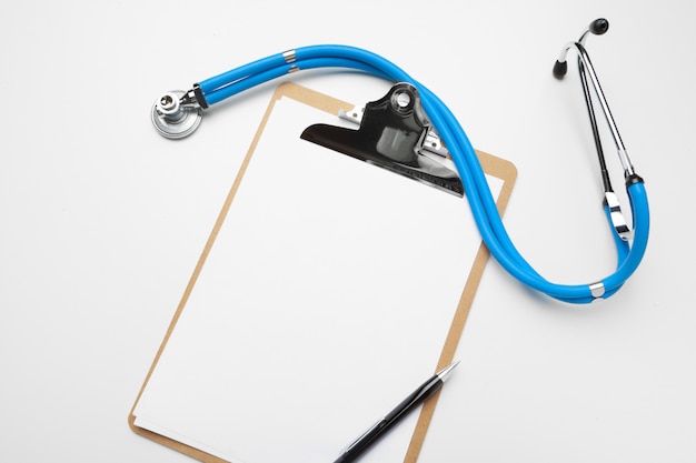 Blank medical clipboard with stethoscope on white background