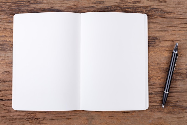 Blank note pad with pen on wood background