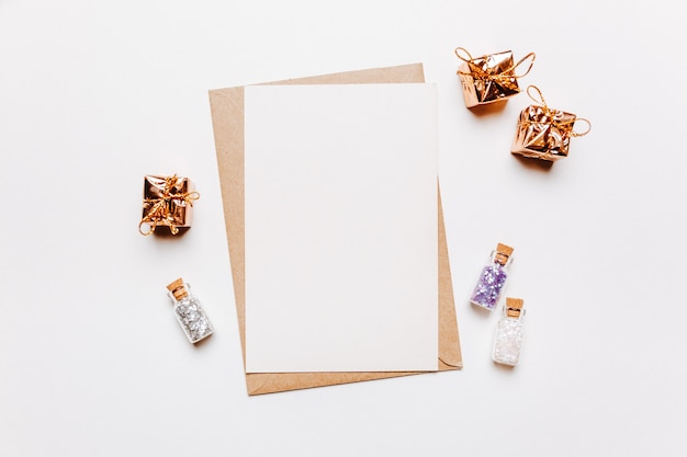 Blank note with envelope, gifts and gold glitter stars on white