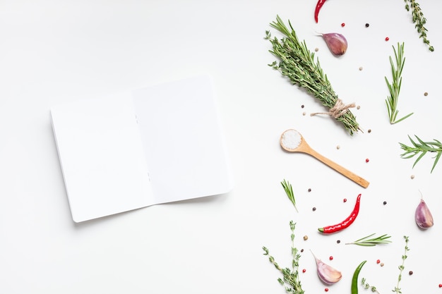 Blank notebook pages mockup text space invitation card on white surface with greens herbs and spices