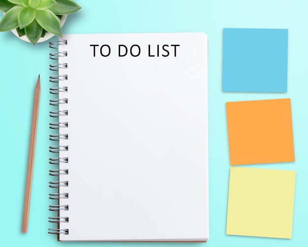 Blank notebook and red alarm clock on work space Office desk for business concept