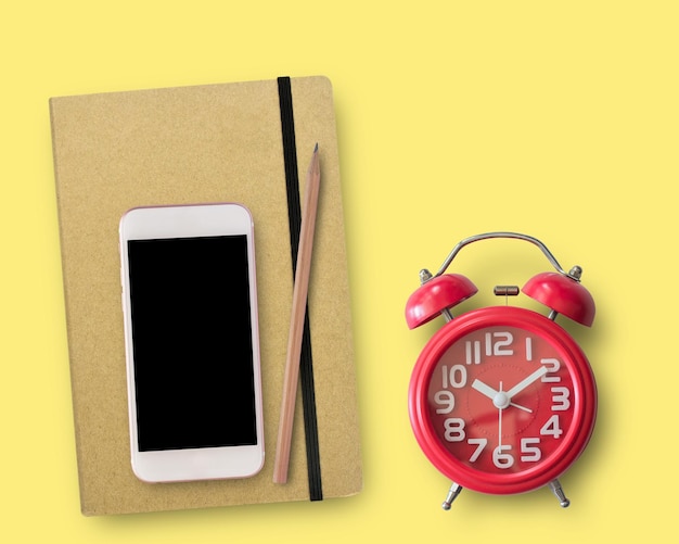 Blank notebook and red alarm clock on work space Office desk for business concept