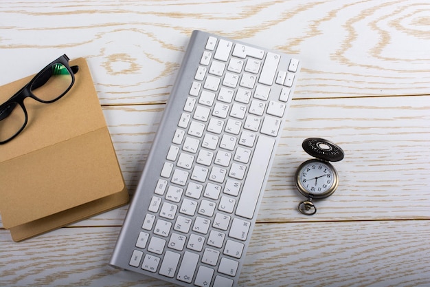 Blank notebook white keyboard and pocket watch