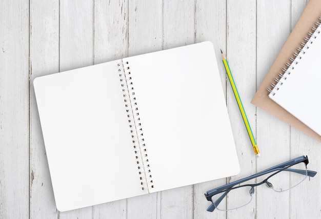 Photo blank notebook with pencil and glasses on office desk