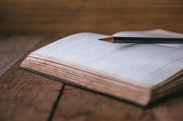 Blank notebook with pencil on wooden table. Selective focus