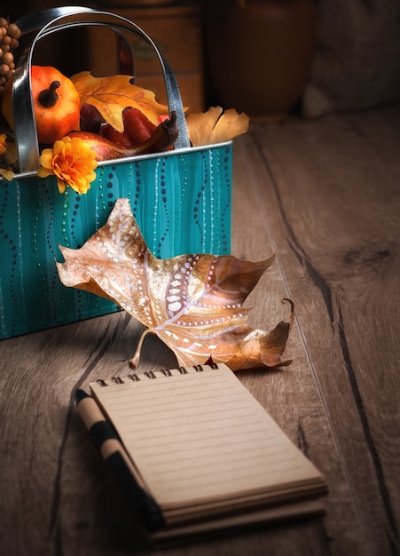 Blank notebook on wooden table with Autumn decorations