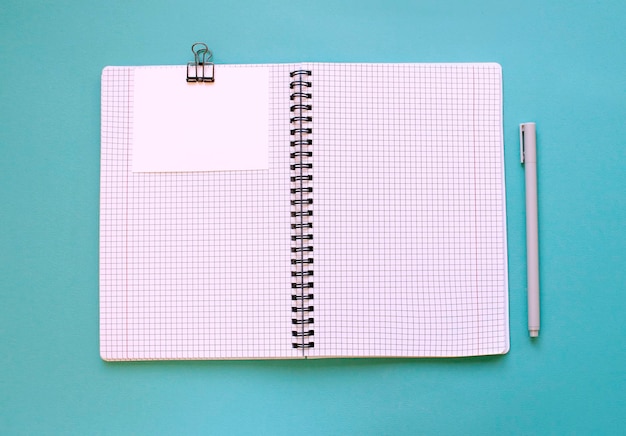 Blank notebook for writing on spirals on a blue background flat lay the end of motivation business building goals with negative industrial space and copy space