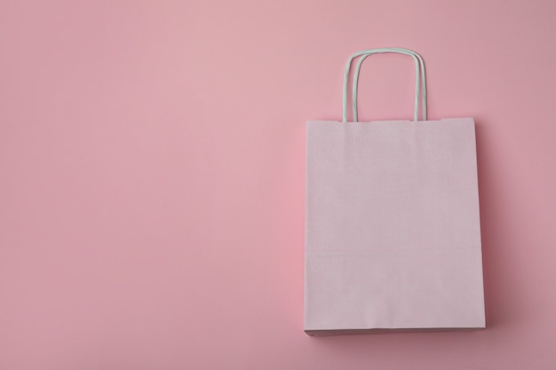 Blank paper bag on pink background, space for text