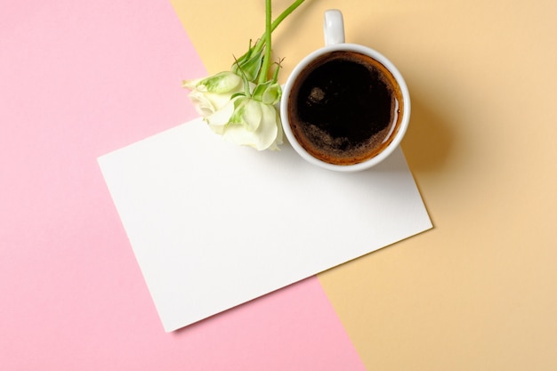 Blank paper card with copy space, cup of coffee and white roses flowers