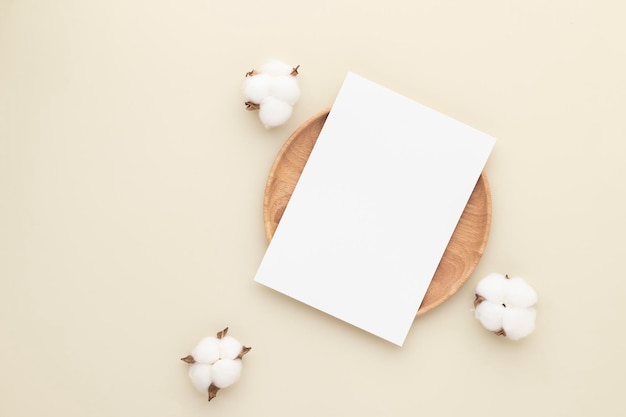 Blank paper cards, Mockup with a cotton flower on a wooden plate, beige background, Minimal beige workplace composition, flat lay, mockup