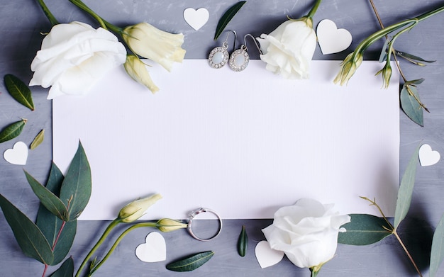 Blank paper copy space. Frame with flowers. Silk ribbon. Gray background. Simple bouquet. Greeting card.