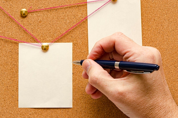 Blank paper notes are pinned to a cork board The concept of detective investigation Copy space